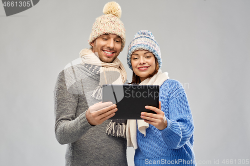 Image of couple in winter clothes with tablet computer