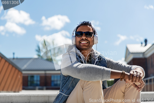 Image of man in headphones listening to music on roof top