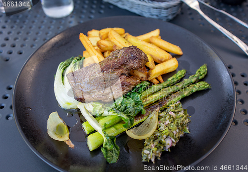 Image of portion of beef fillet steak with vegetables