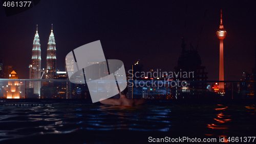 Image of Looking at night Kuala Lumpur cityscape from rooftop pool, Malaysia