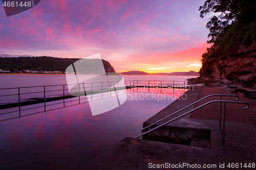 Image of Red and pink dawn skies and reflections in the rock pool