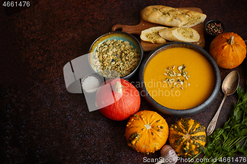 Image of Homemade vegetarian pumpkin cream soup served in ceramic bowl. D