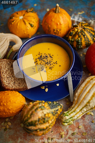 Image of Compositon with autumn classic food. Tasty homemade pumpkin soup decorated with black seed