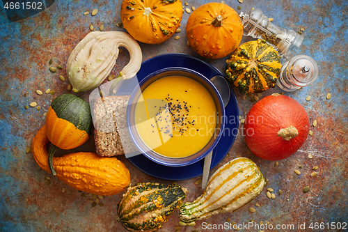 Image of Compositon with autumn classic food. Tasty homemade pumpkin soup decorated with black seed