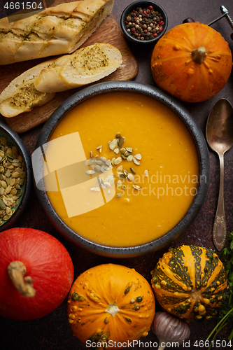 Image of Homemade vegetarian pumpkin cream soup served in ceramic bowl. Decorated with seeds