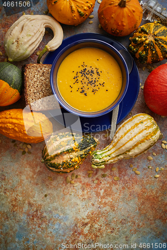 Image of Compositon with autumn classic food. Tasty homemade pumpkin soup decorated with black seed