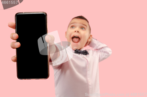 Image of Indoor portrait of attractive young boy holding blank smartphone