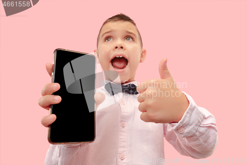 Image of Indoor portrait of attractive young boy holding blank smartphone