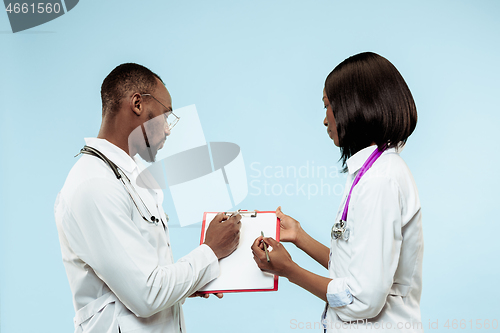 Image of The female and male f happy afro american doctors on blue background