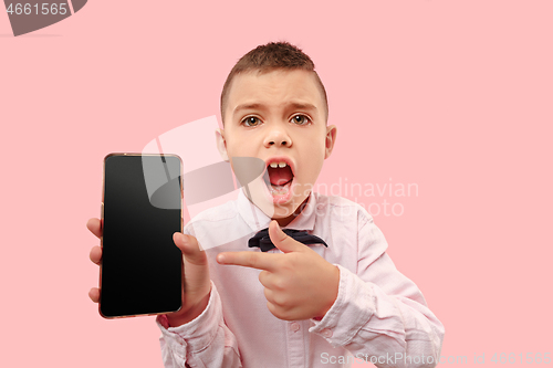 Image of Indoor portrait of attractive young boy holding blank smartphone
