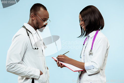 Image of The female and male f happy afro american doctors on blue background