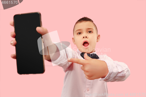 Image of Indoor portrait of attractive young boy holding blank smartphone