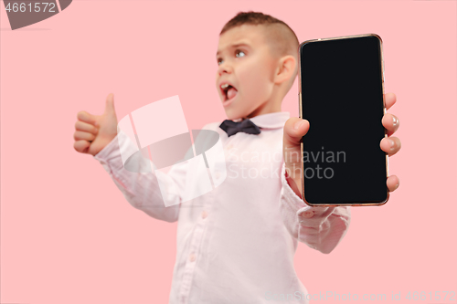 Image of Indoor portrait of attractive young boy holding blank smartphone