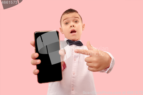 Image of Indoor portrait of attractive young boy holding blank smartphone