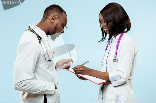 Image of The female and male f happy afro american doctors on blue background