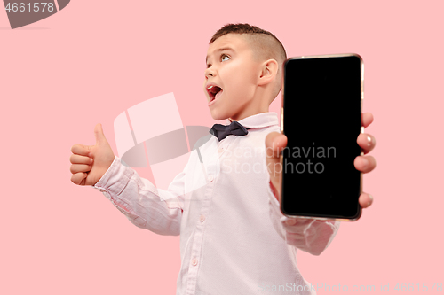 Image of Indoor portrait of attractive young boy holding blank smartphone