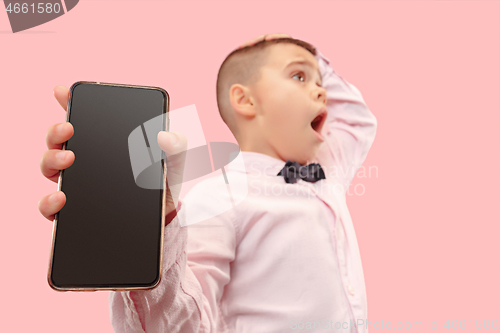 Image of Indoor portrait of attractive young boy holding blank smartphone