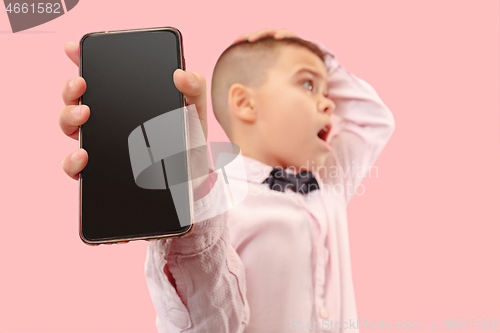 Image of Indoor portrait of attractive young boy holding blank smartphone