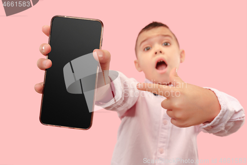 Image of Indoor portrait of attractive young boy holding blank smartphone