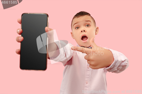 Image of Indoor portrait of attractive young boy holding blank smartphone