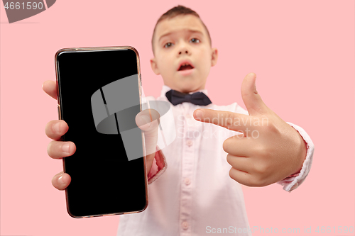 Image of Indoor portrait of attractive young boy holding blank smartphone