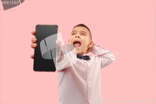 Image of Indoor portrait of attractive young boy holding blank smartphone