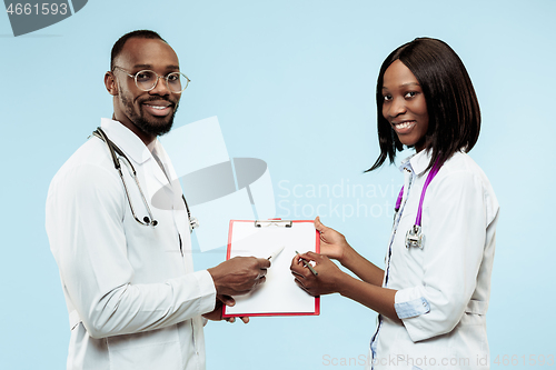 Image of The female and male f happy afro american doctors on blue background