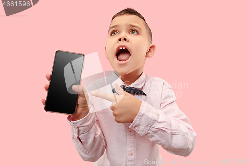 Image of Indoor portrait of attractive young boy holding blank smartphone