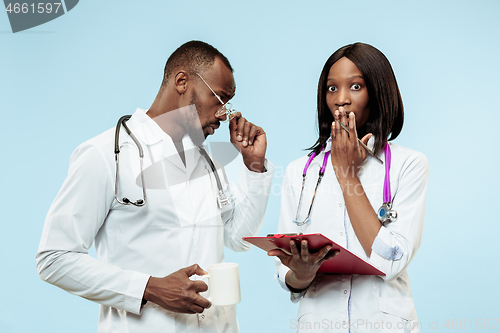 Image of The female and male happy afro american doctors on blue background