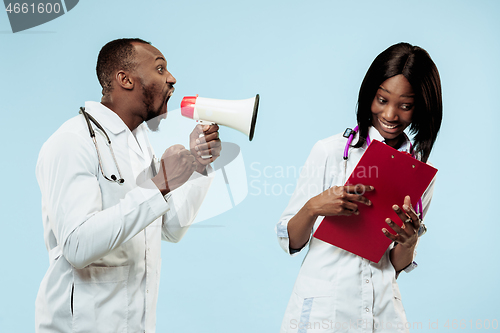 Image of The female and male happy afro american doctors on blue background