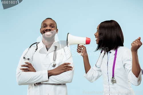 Image of The female and male happy afro american doctors on blue background