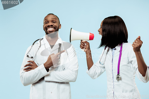 Image of The female and male happy afro american doctors on blue background