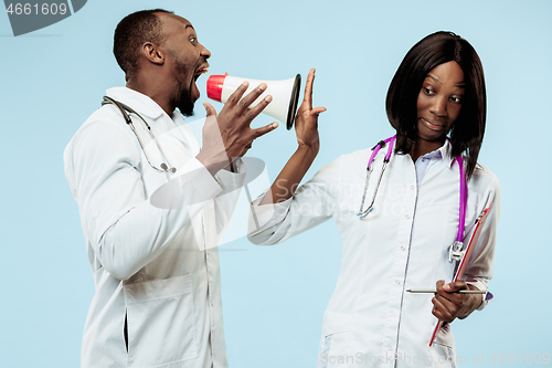 Image of The female and male happy afro american doctors on blue background