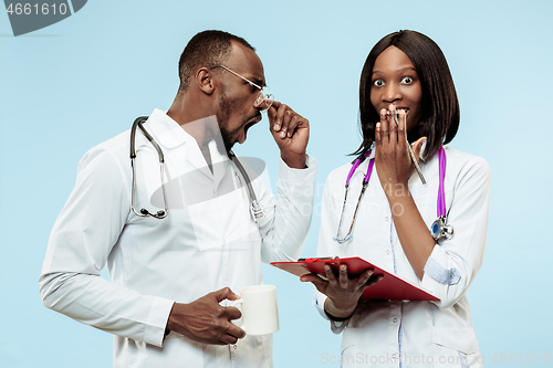 Image of The female and male happy afro american doctors on blue background