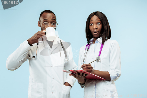 Image of The female and male happy afro american doctors on blue background