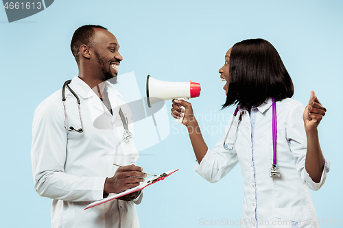 Image of The female and male happy afro american doctors on blue background