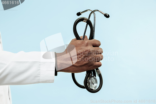 Image of The male hand of afro american doctor on blue background