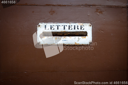 Image of typical mailbox in a wooden door in Italy