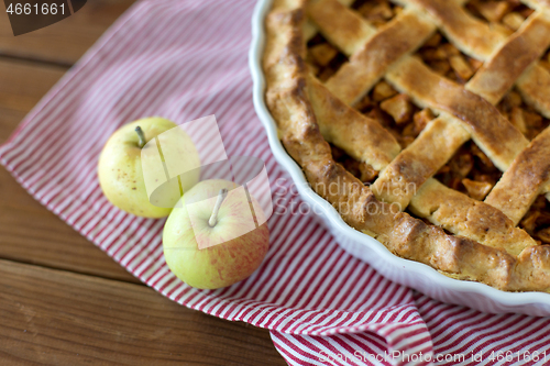 Image of apple pie in baking mold on wooden table