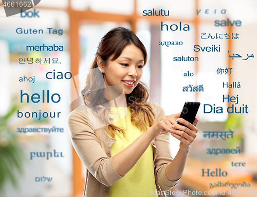 Image of happy asian woman using smartphone