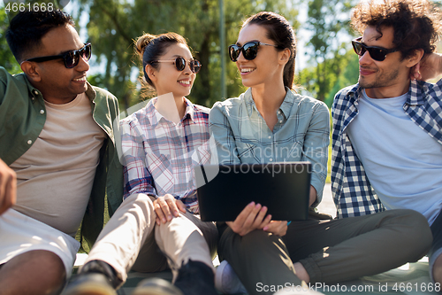 Image of friends with tablet pc computer outdoors in summer