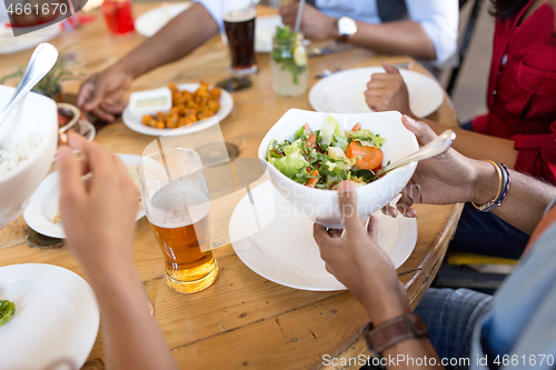 Image of international friends eating at restaurant