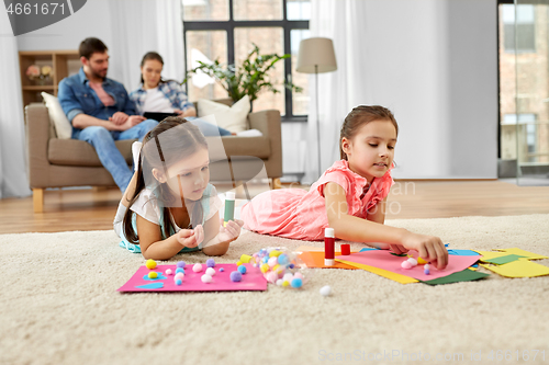 Image of happy sisters doing arts and crafts at home