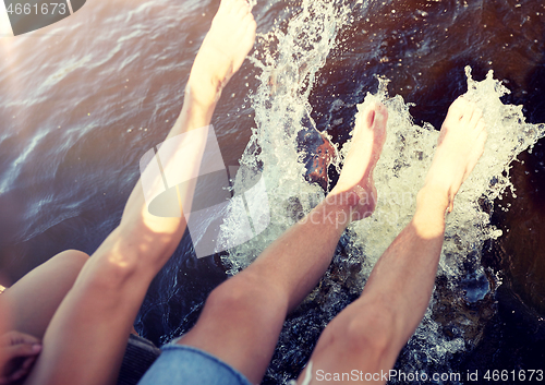 Image of legs of couple splashing water in river