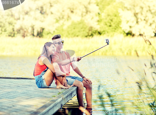 Image of happy teenage couple taking selfie on smartphone