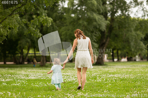 Image of mother with baby daughter walking at summer park