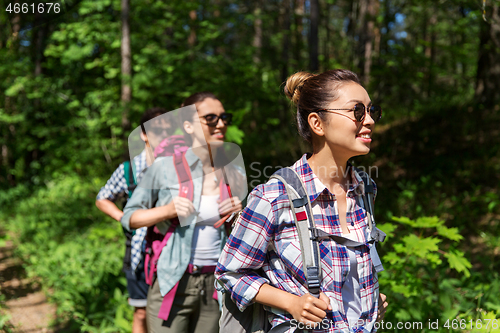 Image of group of friends with backpacks hiking in forest