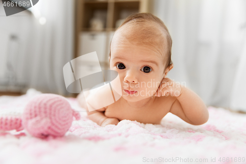 Image of sweet baby girl lying on knitted plush blanket