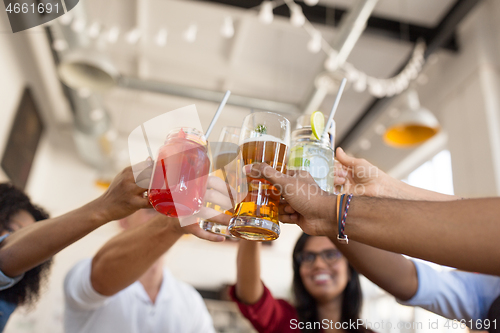 Image of friends clinking glasses at bar or restaurant
