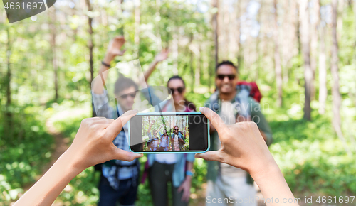 Image of friends with backpacks being photographed on hike